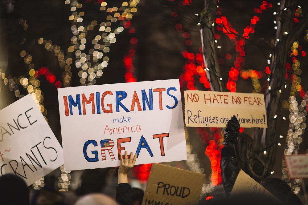People hold up signs supporting immigrants and immigration in America